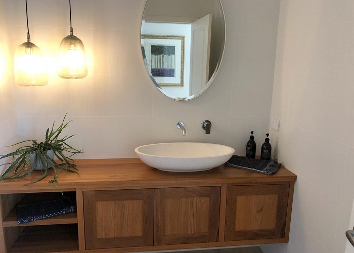 picture of modern bathroom with wooden basinet and white sink, with mirror and lights