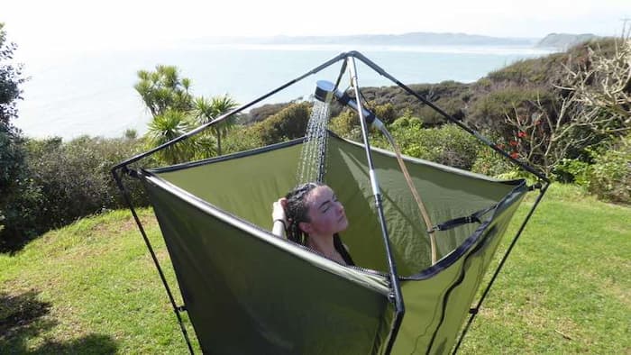 Woman taking shower in a portable camping shower
