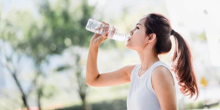 Asian female drinking water from a bottle