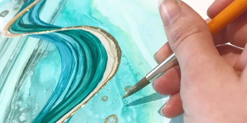 close up of a hand creating alcohol ink abstract art