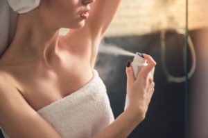 girl putting on deodorant