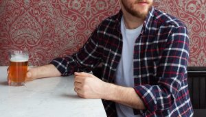 guy wearing flannel shirt drinking beer