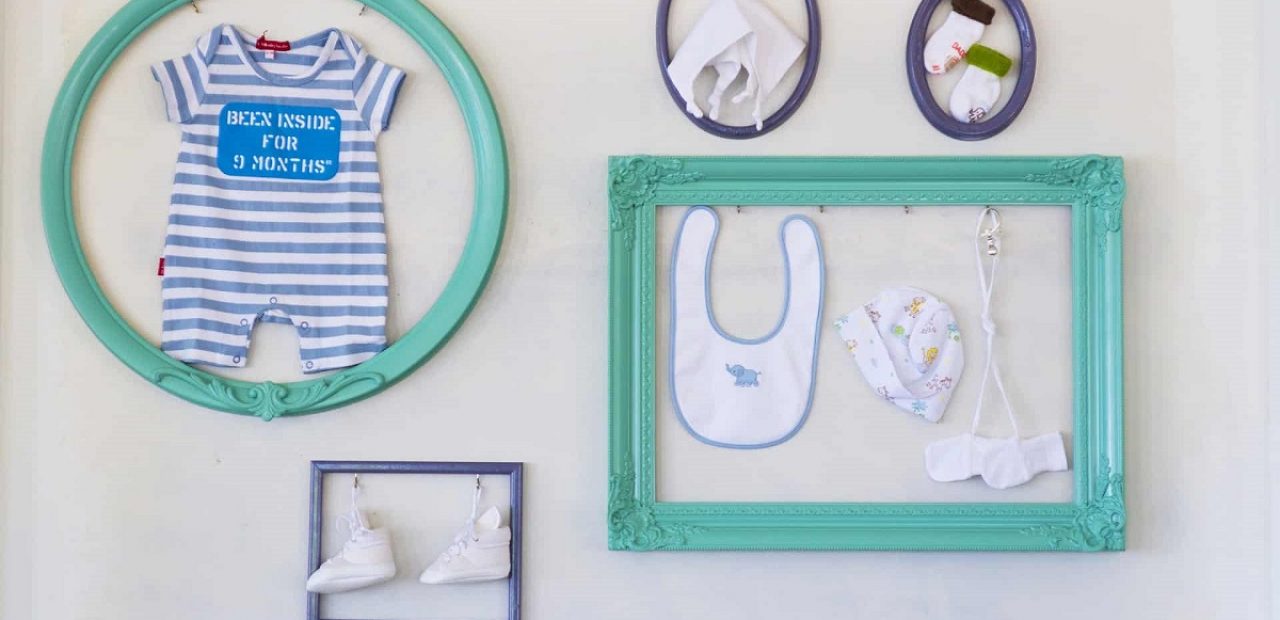 picture of baby's stuff in a blue frames on the wall