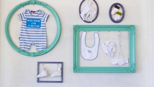 picture of baby's stuff in a blue frames on the wall