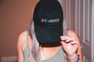 picture of woman wearing top and black baseball hat with letters