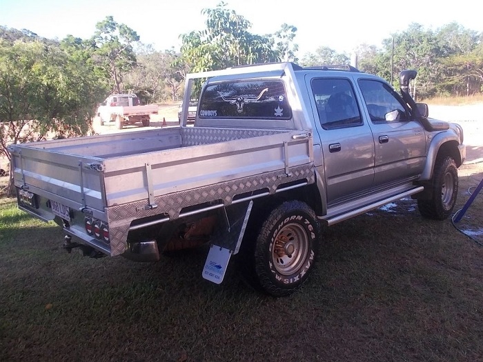 picture of aluminum ute trays on grass between trees 