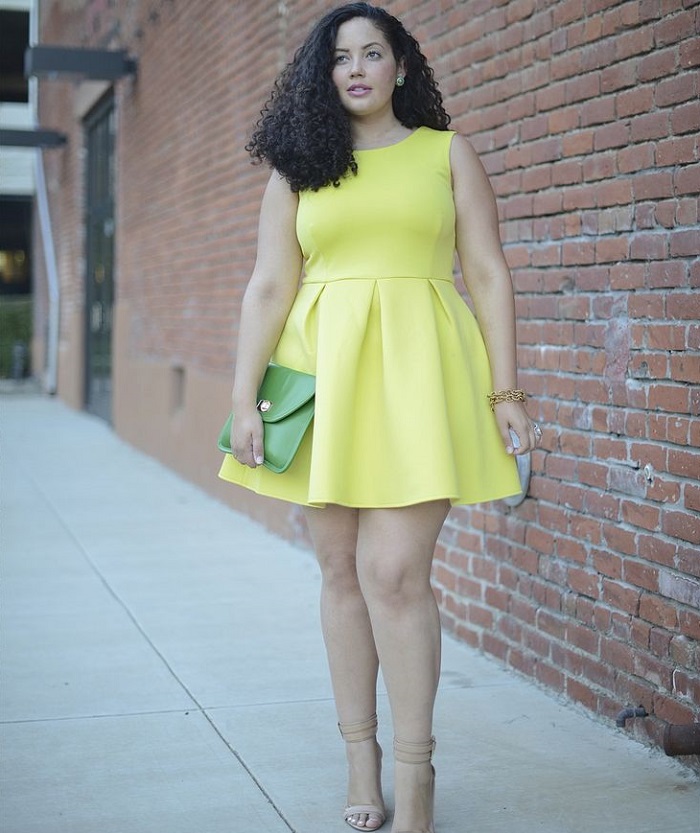 picture of a woman in yellow dress standing on the sidewalk