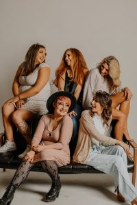 picture of women in different type of bodies sitting in front brown background