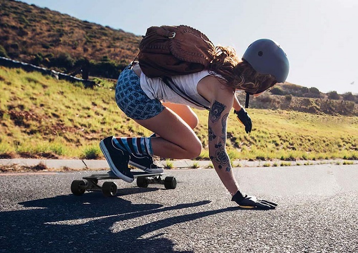woman skateboard cruising down a road 