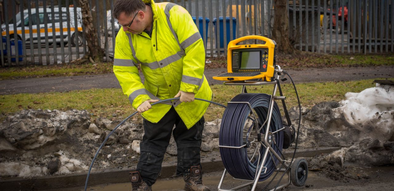 Man inspecting sewer pipes with sewer camera