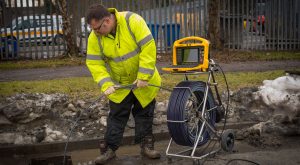Man inspecting sewer pipes with sewer camera