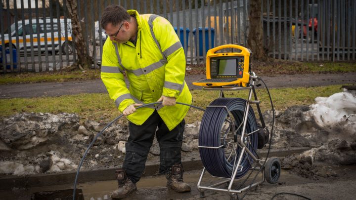 Man inspecting sewer pipes with sewer camera