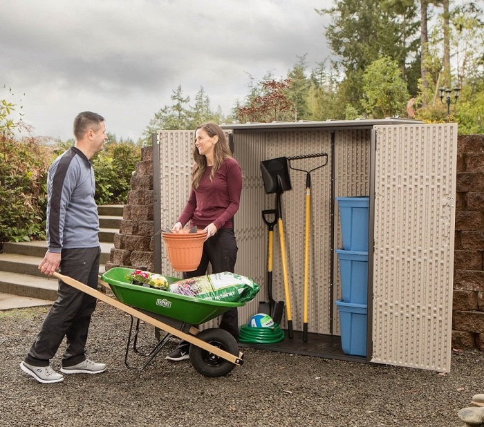 couple standing in front of small prefab plastic shed 