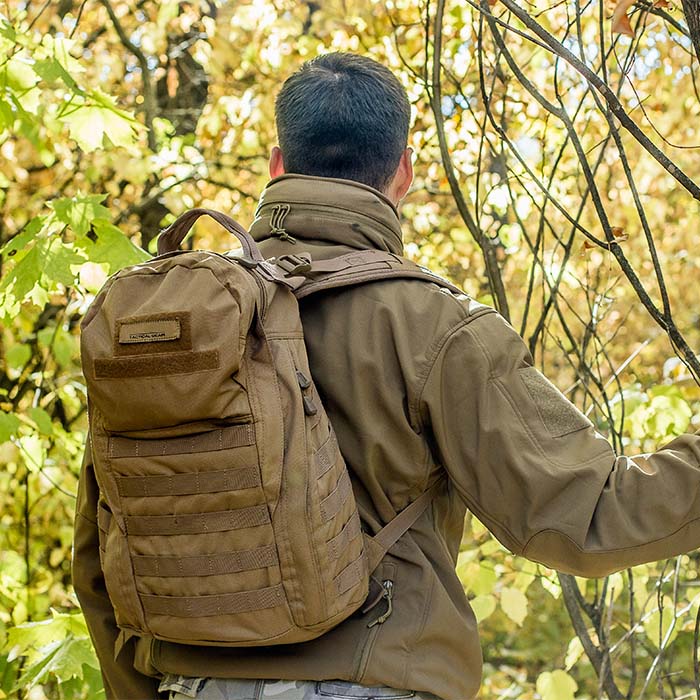 Man wearing tactical backpack in the woods