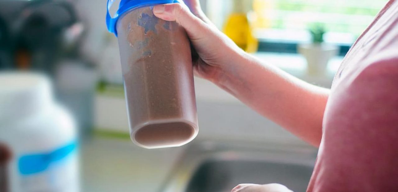 a person shaking a protein shake which is best used for weight loss