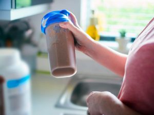 a person shaking a protein shake which is best used for weight loss