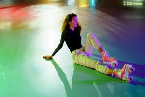 picture of girl sitting on a floor with a girls quad skates put on