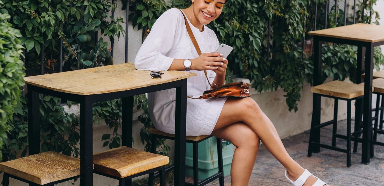 picture of a woman sitting on a high table outside wearing womens dress sandals