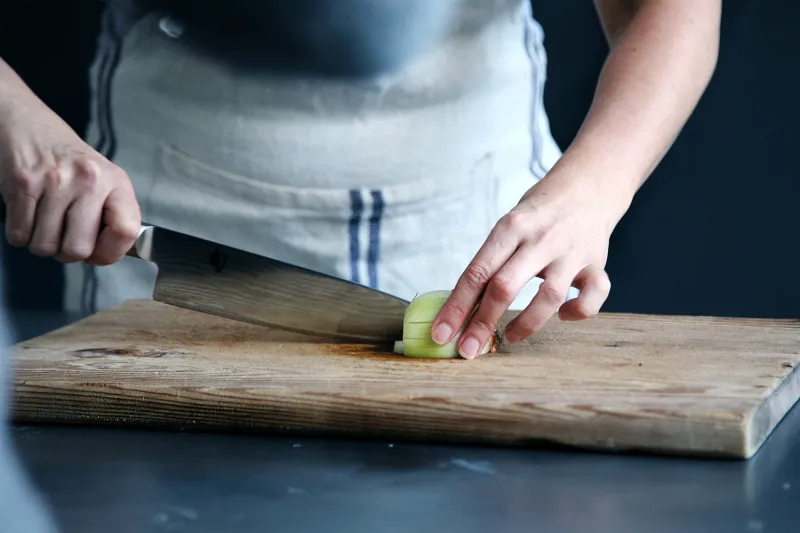 man cutting on a cutting board with knife