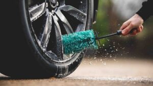 man cleaning his car tyres