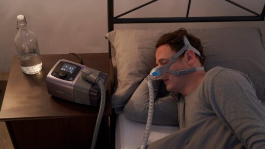 man sleeping while using auto cpap machine