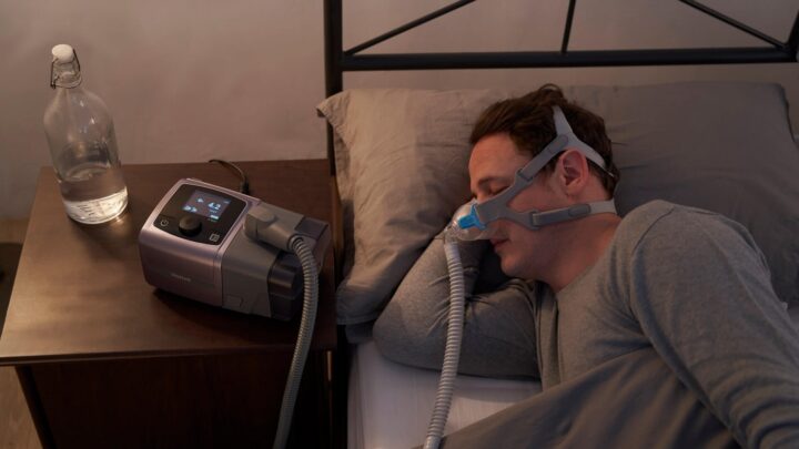 man sleeping while using auto cpap machine