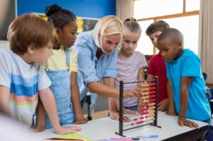teacher with children using teaching aid and props