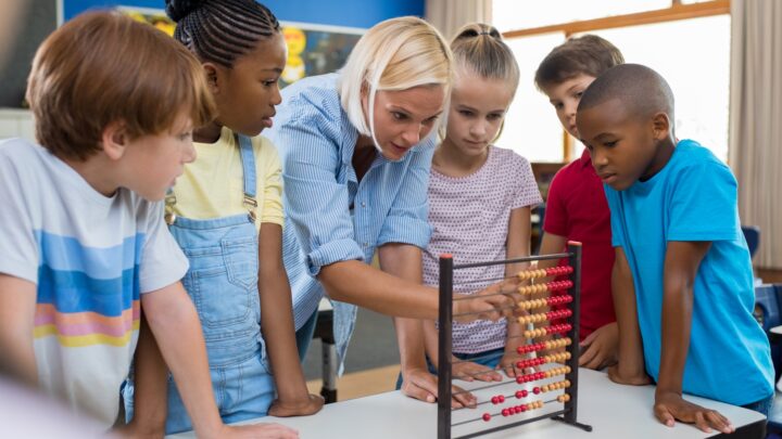 teacher with children using teaching aid and props