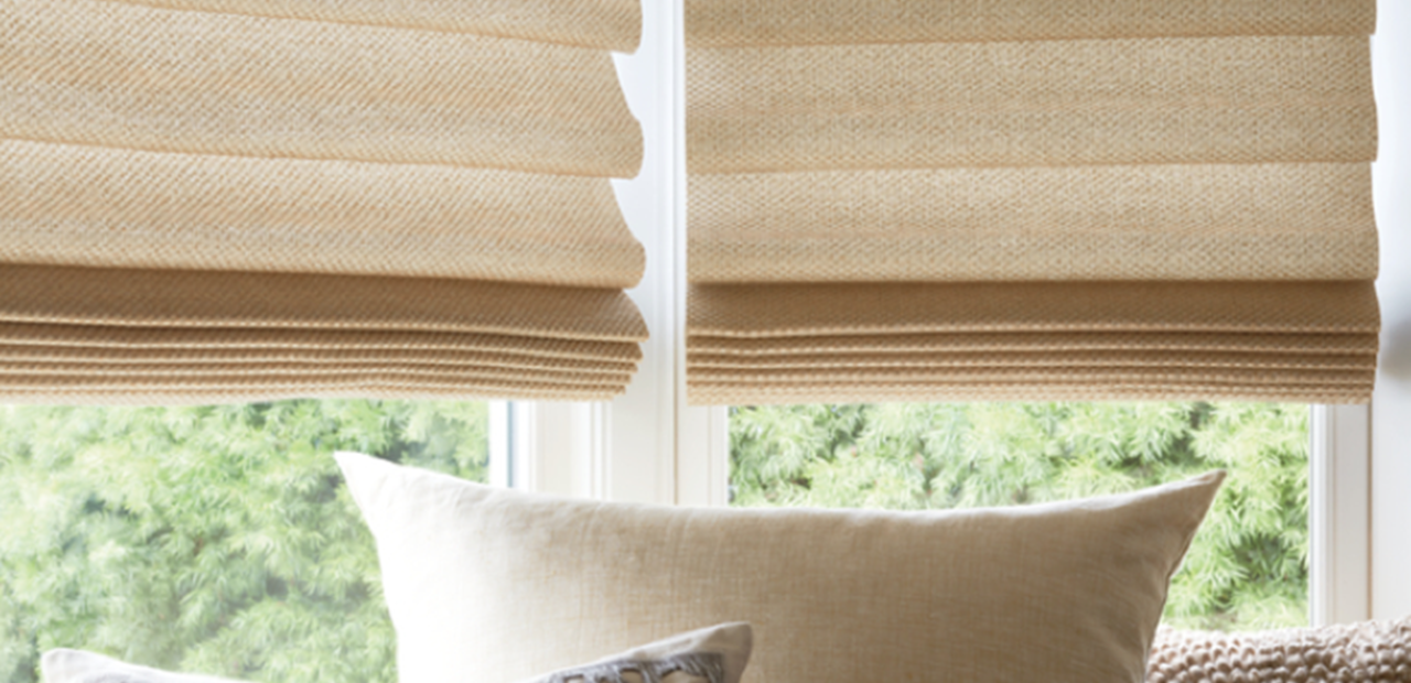 blinds of fabrics on a window and pillows below them