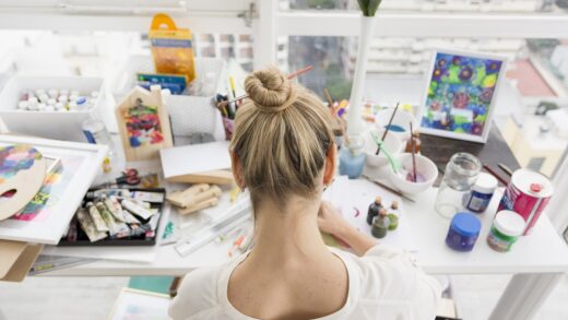 woman on a table with a lot of art and craft materials
