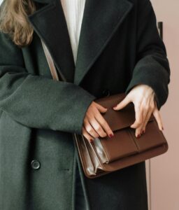 woman holding brown leather bag