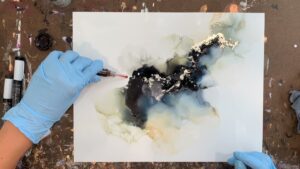 woman creating abstract art with alcohol ink