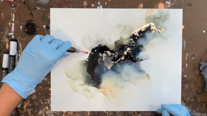 woman creating abstract art with alcohol ink